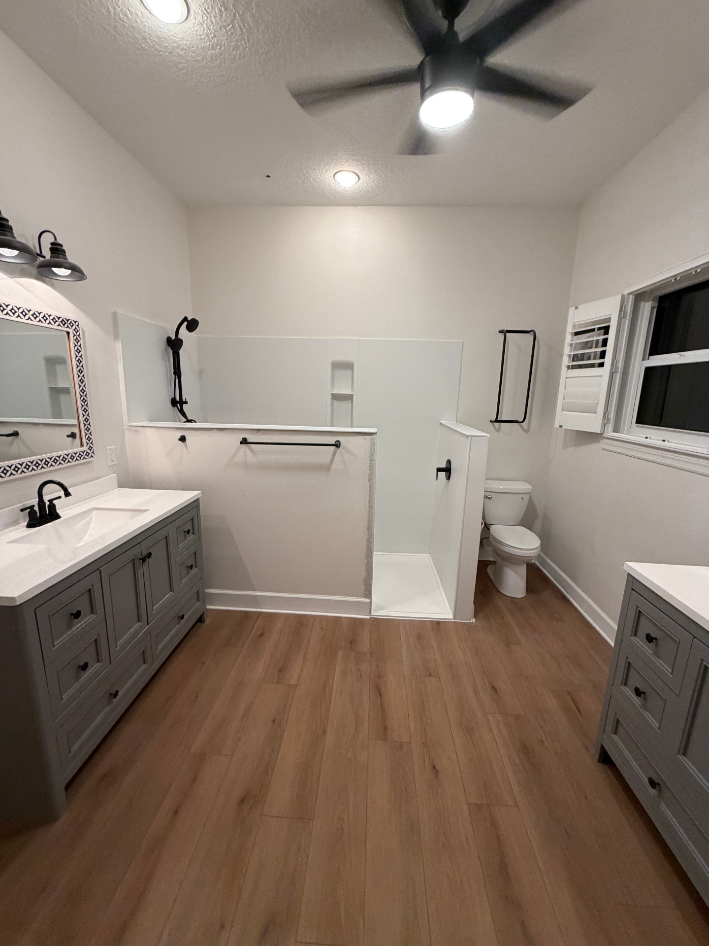 Owner-installed Tampa Bay bathroom remodel — walk-in shower with matte-black fixtures